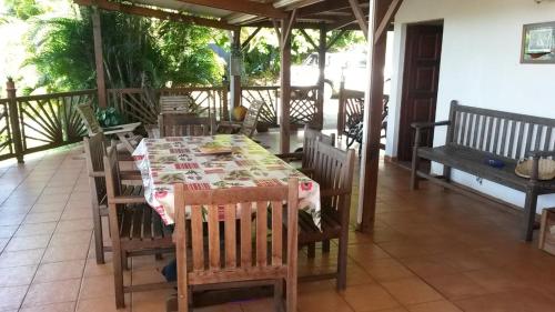 - une table et des chaises sur la terrasse couverte d'une maison dans l'établissement Studio BELO HORIZONTE, Grande terrasse avec vue sur les Pitons, à Le Robert