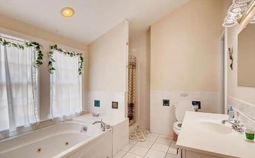 uma casa de banho com uma banheira, um WC e um lavatório. em West Tisbury Inn em West Tisbury