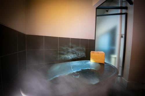 a bathroom with a tub with a wooden block in it at Kunisakisou in Beppu