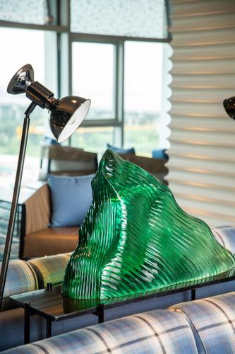 a green glass sculpture sitting on a table next to a lamp at Crowne Plaza Shenzhen World Exhibition and Convention Center by IHG in Shenzhen