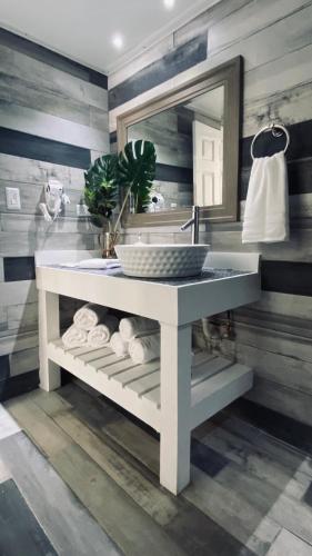 a bathroom with a sink and a mirror and towels at Blue House Joyuda in Cabo Rojo