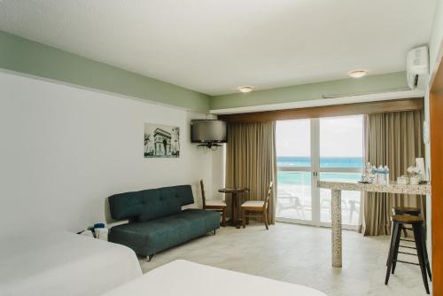 a hotel room with a bed and a couch and a table at Condominio Girasol OceanView in Cancún