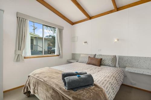 a bedroom with a bed with a gray bag on it at Mittagong Caravan Park in Mittagong