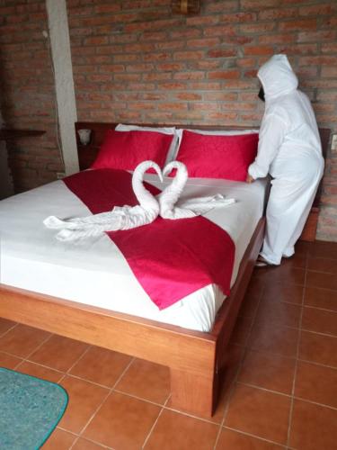 a bed with two white towels on it at Hosteria Cumilinche in Same