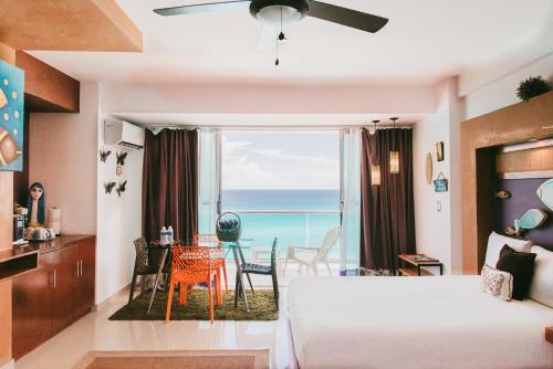a living room with a bed and a table with chairs at Condominio Girasol OceanView in Cancún