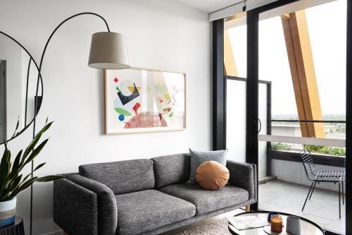 a living room with a couch and a table at Punthill Ivanhoe in Melbourne