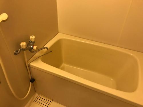 a bath tub in the corner of a bathroom at Renaissance Tanagura in Shirakawa