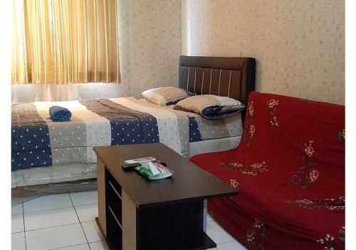 Zimmer mit 2 Betten, einem Tisch und einem Stuhl in der Unterkunft Royal Property in Jakarta