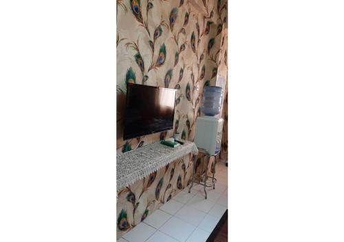 Zimmer mit einem TV und einer Tapete an der Wand in der Unterkunft Royal Property in Jakarta