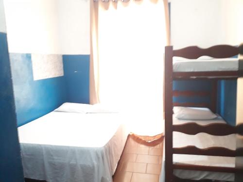 a bedroom with two bunk beds and a window at Pousada das Goianas in Santos