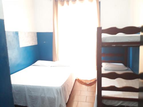 a bedroom with two bunk beds and a window at Hotel e Pousada das Goianas in Santos