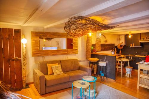ein Wohnzimmer mit einem Sofa und einer Küche in der Unterkunft végétal cocoon in Annecy