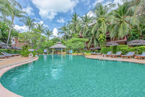 a swimming pool at a resort with palm trees at Kata Palm Resort - SHA Plus in Kata Beach