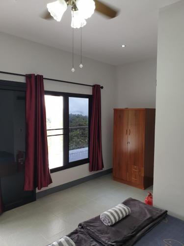 a bedroom with a bed and a window with red curtains at DOI TUNG Anisa Homestay in Chiang Rai