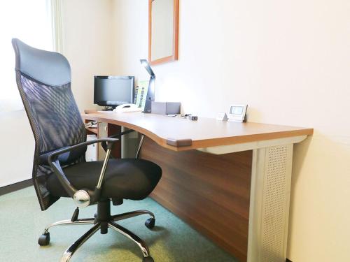 an office with a desk with a chair and a computer at Odawara Terminal Hotel in Odawara