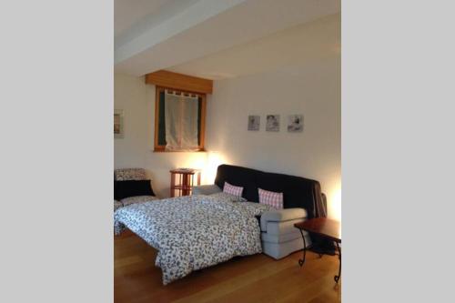 ein Schlafzimmer mit einem Bett und einem Sofa in der Unterkunft Apartment Del Sol Etoile 1 Crans Montana Switzerland in Crans-Montana