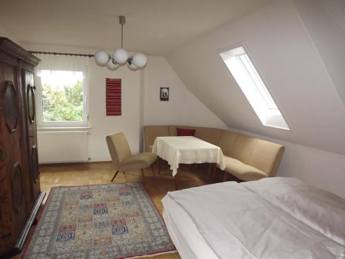 a bedroom with a bed and a table and a room with a bed at Große Ferienwohnung am grünen Stadtrand in Erfurt