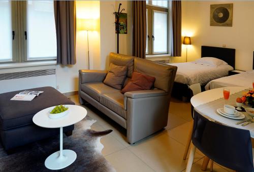 a living room with a couch and a table at Apartments Ypres in Ypres