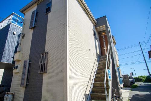 a building with stairs leading up to a door at KOSHIGOE seaside inn in Kamakura