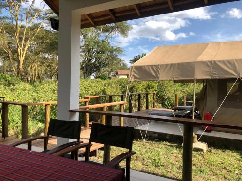 a tent on a porch with a table and chairs at Enjoy the Silence, Naivasha by YourHost in Naivasha