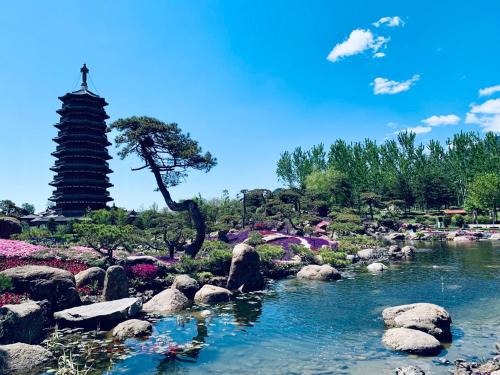 a garden with a river and rocks and a pagoda at Yanqi Hotel, Managed by Kempinski in Huairou