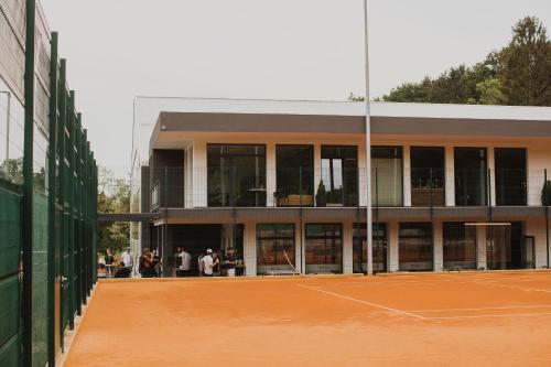 a building with a tennis court in front of it at Center Vintgar in Slovenska Bistrica