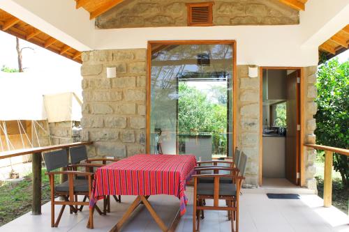 a dining room with a table and chairs on a patio at Enjoy the Silence, Naivasha by YourHost in Naivasha