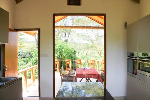 a kitchen with a glass door leading to a patio at Enjoy the Silence, Naivasha by YourHost in Naivasha