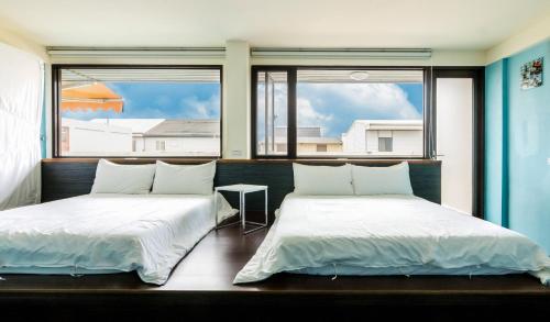 羅東鎮的住宿－BoBo旅店 ，带2扇窗户的客房内的2张床