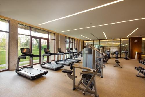 a gym with a row of treadmills and machines at Yanqi Hotel, Managed by Kempinski in Huairou