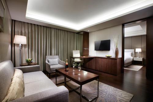 テジョンにあるLOTTE City Hotel Daejeonのリビングルーム(ソファ、ベッド、テレビ付)