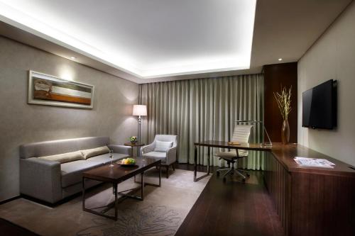 a living room with a couch and a table at LOTTE City Hotel Daejeon in Daejeon