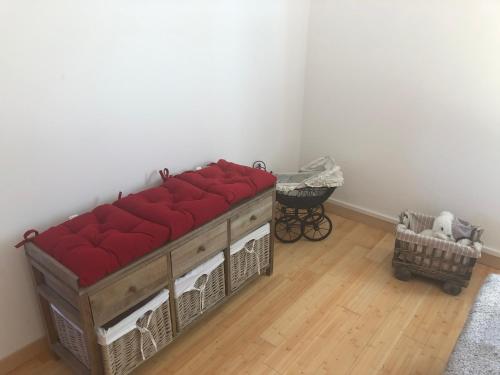 una cama con cojines rojos en una habitación en Maison du bonheur, en Saint-Mards-de-Fresne