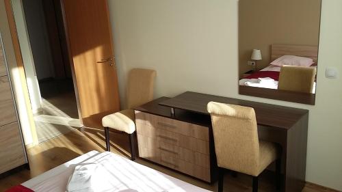 ソフィアにあるApartments Mladost 1Aのデスク、鏡、ベッドが備わる客室です。