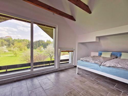 a bedroom with a bed and a large window at Deerwood-Large Villa relax with castle view in Bled