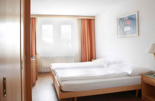 a bedroom with two beds and a window at Saaserhof Apartments in Saas-Fee