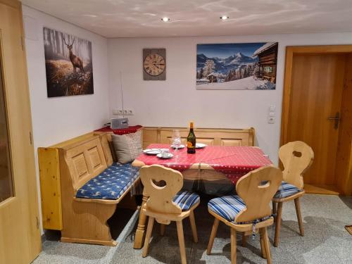 comedor con mesa, sillas y reloj en Landhaus-Willi, en Gaschurn