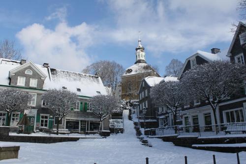 a snow covered street with buildings and a church at Kleine 25 in Solingen