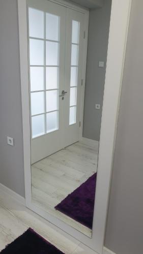 a mirror reflection of a room with a door at Apartman Sweet dreams 2 in Niš