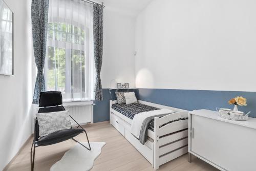 um pequeno quarto com uma cama e uma cadeira em Vila ELIS em Jeseník