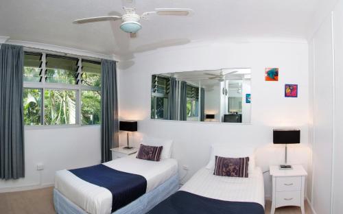 a bedroom with two beds and a mirror at Poinciana 112 Bedrooms x3 Free Buggy in Hamilton Island