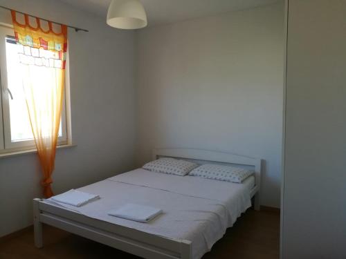 un letto in una stanza con una finestra di Apartment Pehi a Supetar (San Pietro di Brazza)