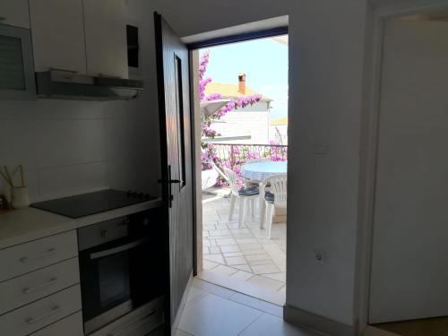 porta aperta a una cucina con vista su un patio di Apartment Pehi a Supetar (San Pietro di Brazza)