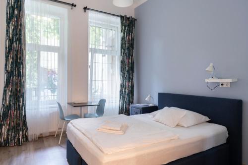 a bedroom with a bed and a large window at Vajda 15 Hostel Budapest in Budapest