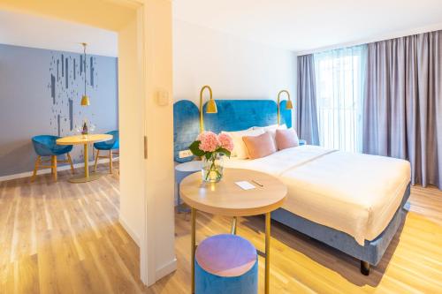 um quarto de hotel com uma cama e uma mesa em Capri by Fraser Leipzig em Leipzig