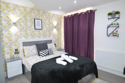 1 dormitorio con 1 cama con 2 toallas en Stylish Central Self contained flat by CozyNest en Reading
