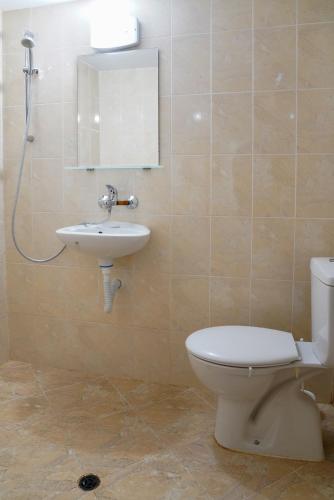 a bathroom with a toilet and a sink at Екокомплекс Катунище in Katunishte