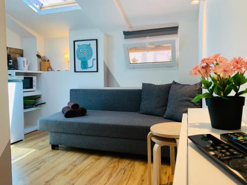 un salon avec un canapé bleu et une table dans l'établissement COURONNE STUDIO, à Aix-en-Provence