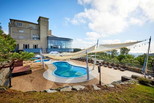 ein großer Pool mit einem großen Gebäude im Hintergrund in der Unterkunft Gyeongju Mauna Ocean Resort in Gyeongju