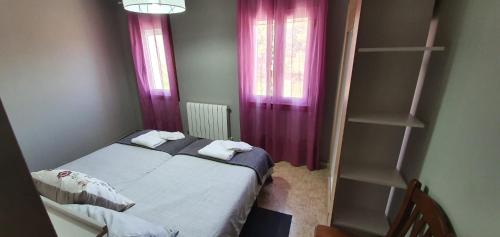 1 dormitorio pequeño con cama y cortinas moradas en Apartamentos Portolux, en Portomarín
